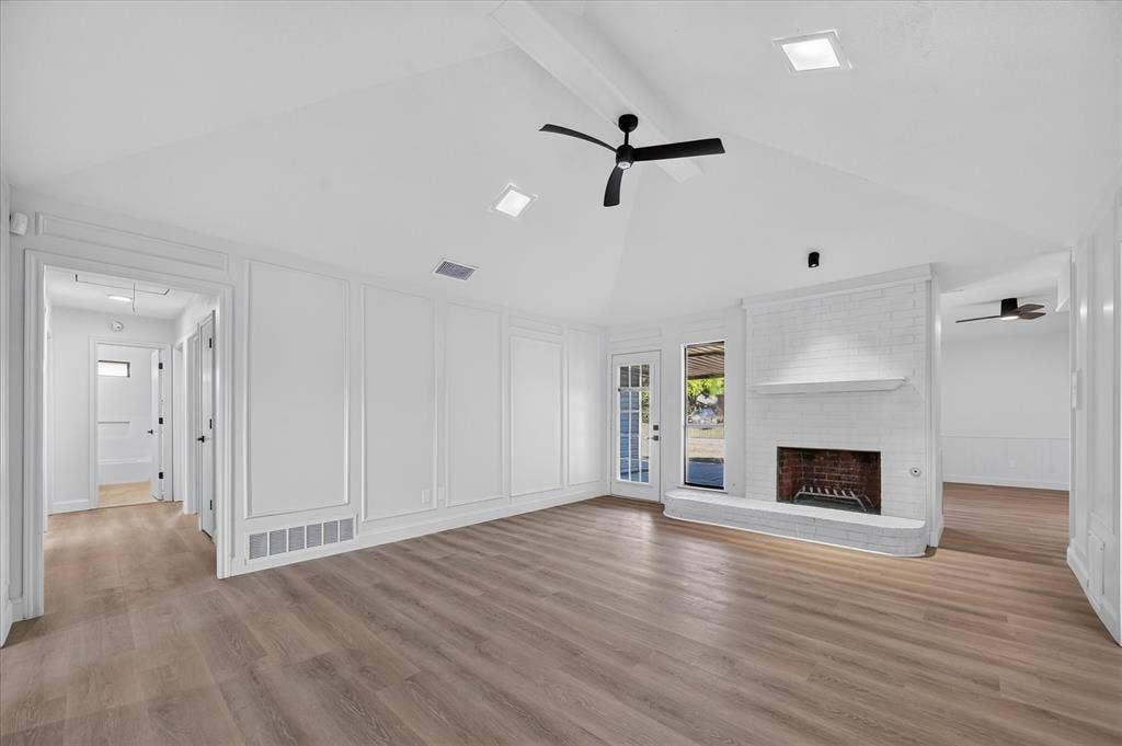 1528 Estrella Drive, Plano, TX 75074 Vaulted ceilings, wood-finish flooring, white brick fireplace, panel molding details, and recessed lighting