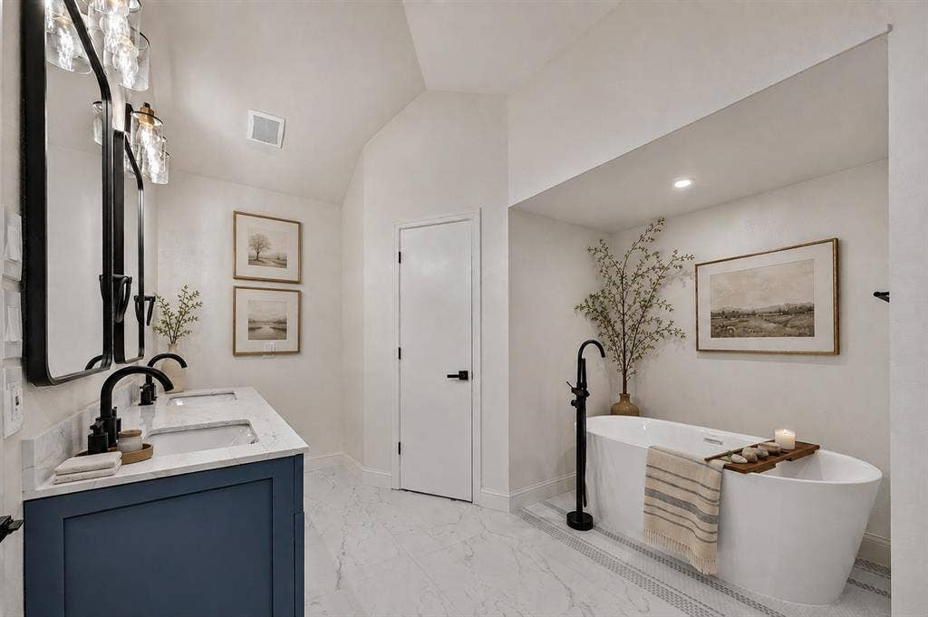 1528 Estrella Drive, Plano, TX 75074 Vaulted ceiling, dual vanity with undermount sinks, freestanding soaking tub, matte black fixtures, and marble-look tile flooring
