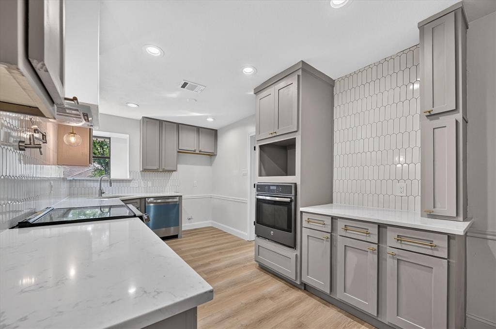 1528 Estrella Drive, Plano, TX 75074 Modern Kitchen featuring taupe cabinetry, white countertops, wood-finish flooring, a stainless steel range, and a white picket tile backsplash
