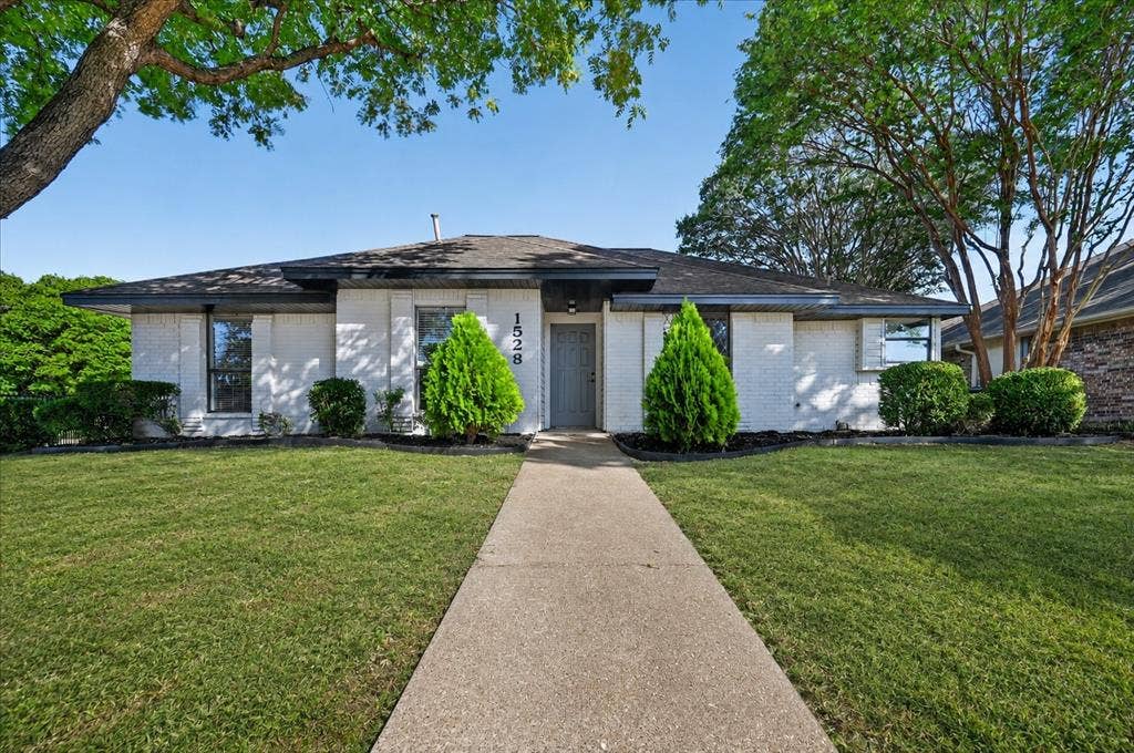 1528 Estrella Drive, Plano, TX 75074 White brick exterior with dark trim and a dark roof