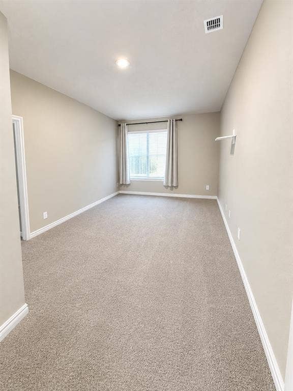 7204 Running Iron Trail, Sachse, TX 75048 Plush carpet flooring, neutral paint tones, recessed ceiling lighting, and a window with blinds