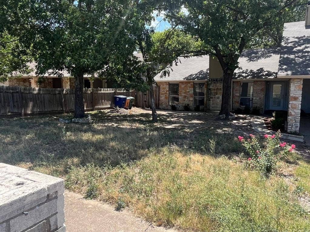 9515 Aberdeen Way, Austin, TX 78753 Stone and stucco exterior, mature trees, wood privacy fence, concrete walkway, small flowering shrub