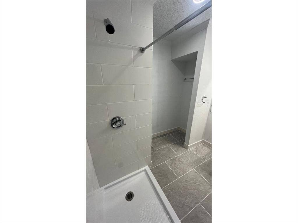 9515 Aberdeen Way, Austin, TX 78753 Shower with white subway tile surround, chrome fixtures, and a white shower pan