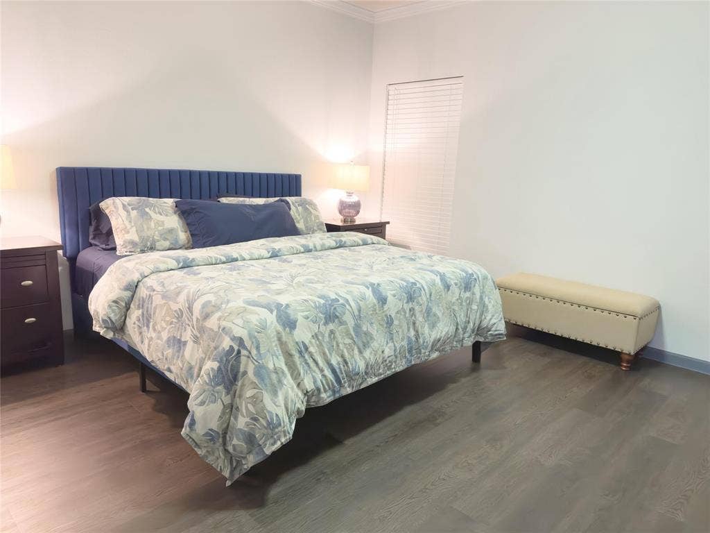 12146 Gonzales Drive, Frisco, TX 75035 Bedroom featuring crown molding, wood finished floors, and baseboards