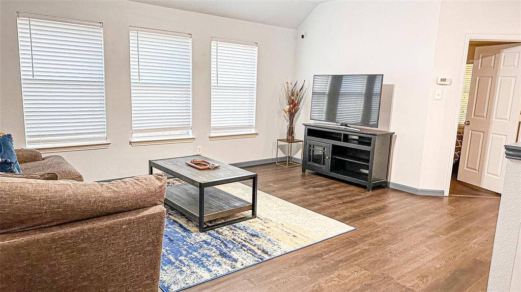 12146 Gonzales Drive, Frisco, TX 75035 Living room with wood finished floors, lofted ceiling, and baseboards