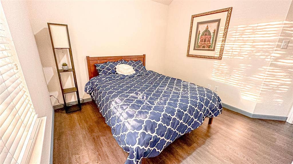 12146 Gonzales Drive, Frisco, TX 75035 Bedroom featuring wood finished floors and baseboards
