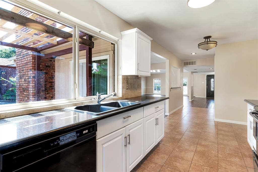 925 Lombardy Drive, Plano, TX 75023 Kitchen featuring white cabinetry, dark countertops, a dual basin sink, a built-in dishwasher, and tile flooring