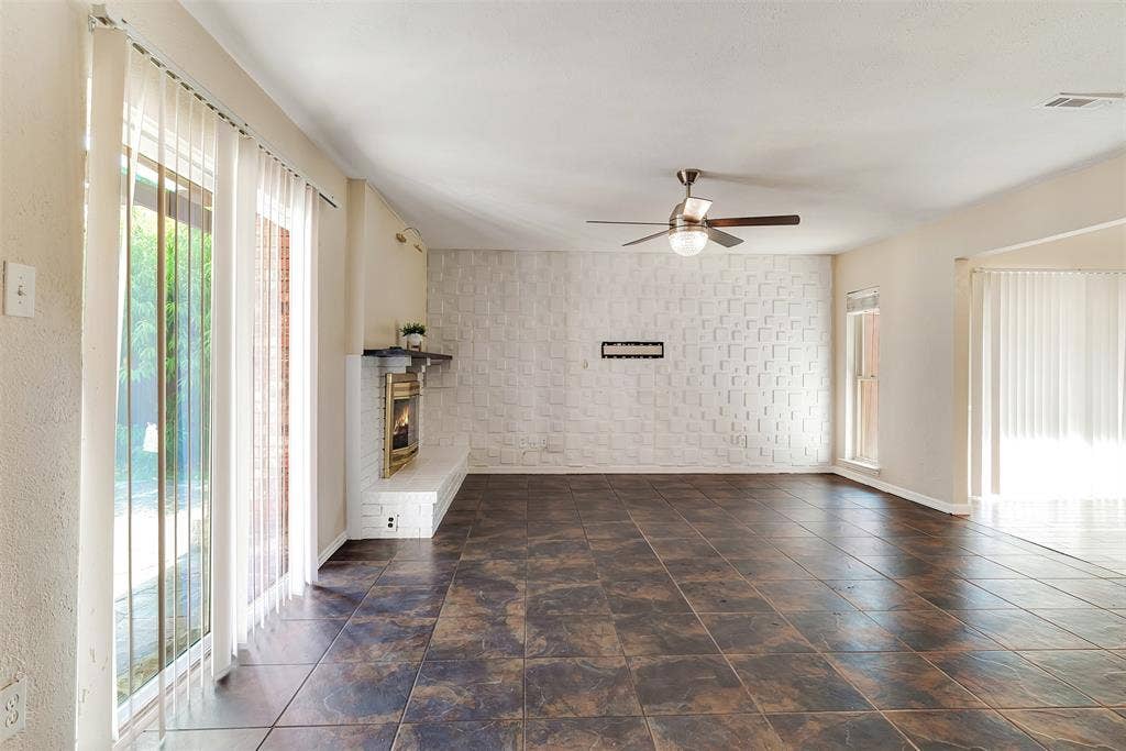 925 Lombardy Drive, Plano, TX 75023 Tiled flooring, brick fireplace with mantel, ceiling fan, and sliding glass doors