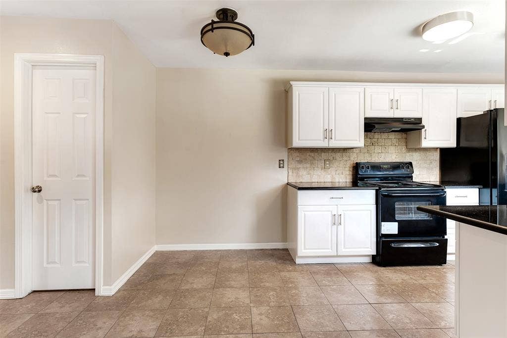 925 Lombardy Drive, Plano, TX 75023 Kitchen featuring white cabinetry, black appliances, dark countertops, and a tiled backsplash