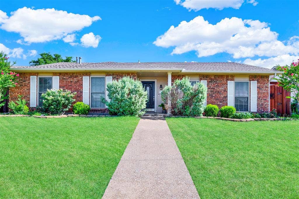 925 Lombardy Drive, Plano, TX 75023 Brick exterior with white shutters and a covered porch
