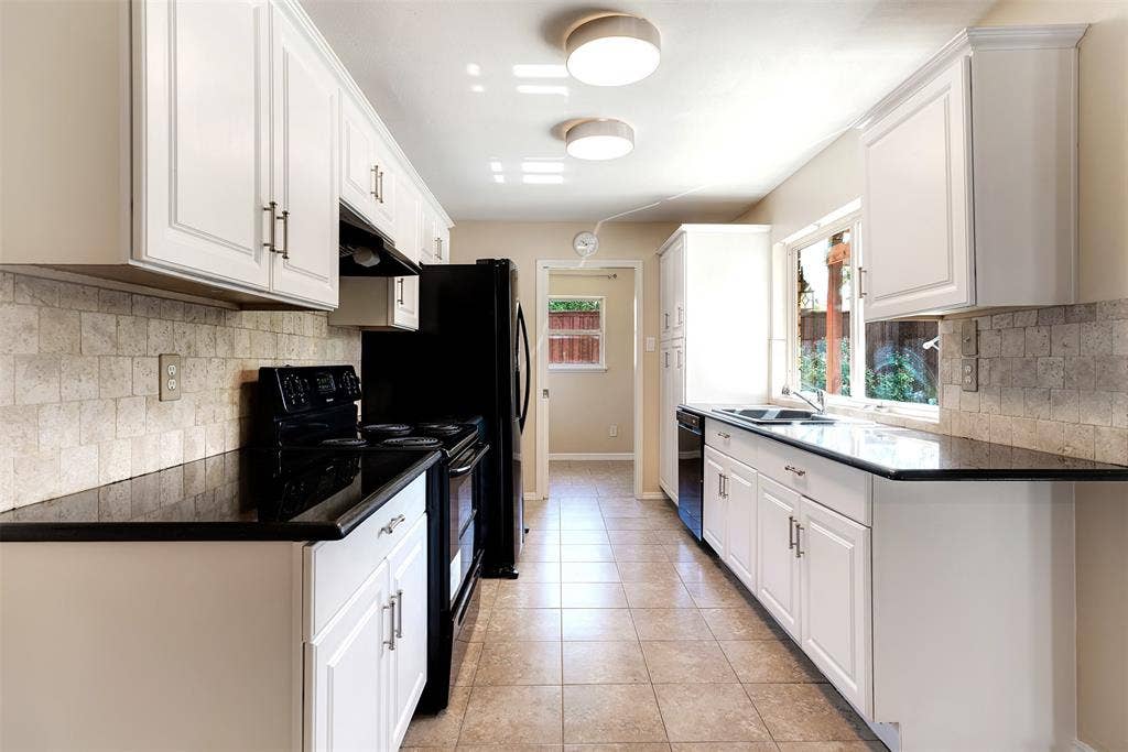 925 Lombardy Drive, Plano, TX 75023 Galley kitchen featuring white cabinetry, dark countertops, tiled flooring, and a tiled backsplash