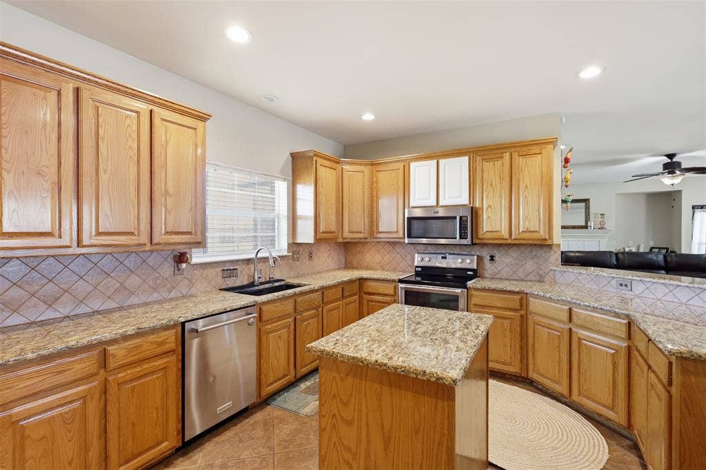 5642 County Road 597, Farmersville, TX 75442 Large kitchen features island, granite countertops, stainless steel appliances and natural wood cabinets.