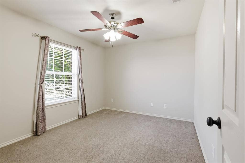 5642 County Road 597, Farmersville, TX 75442 Third bedroom with large window and ceiling fan.