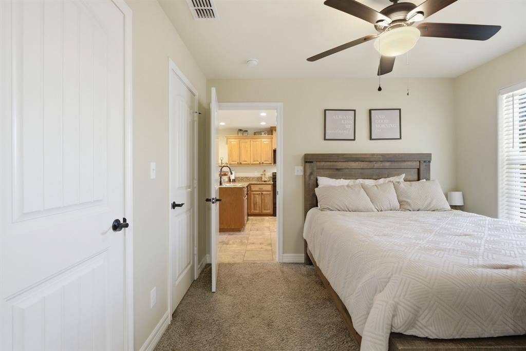 213 Freeman Street, Lindale, TX 75771 Ceiling fan with integrated lighting, wood-finish headboard, window with horizontal blinds, neutral wall paint, and plush carpet flooring