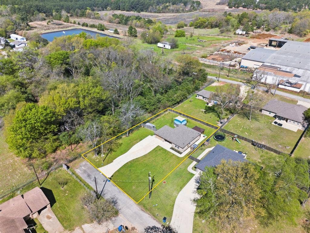 213 Freeman Street, Lindale, TX 75771 Spacious property featuring a single-story residence, extensive green lawn, paved driveway, and perimeter fencing