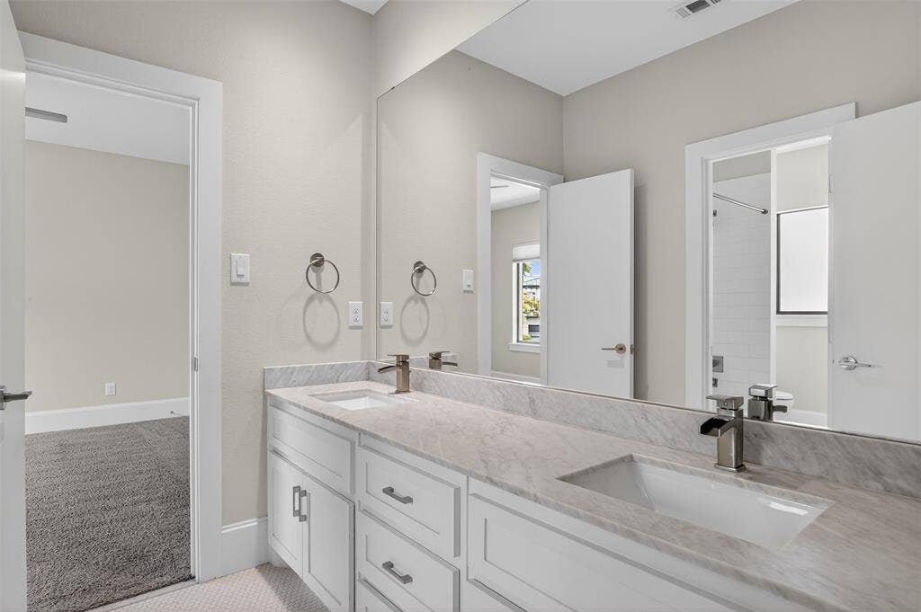 5328 Manett Street, Dallas, TX 75206 Double vanity with a stone countertop, undermount sinks, and brushed nickel fixtures