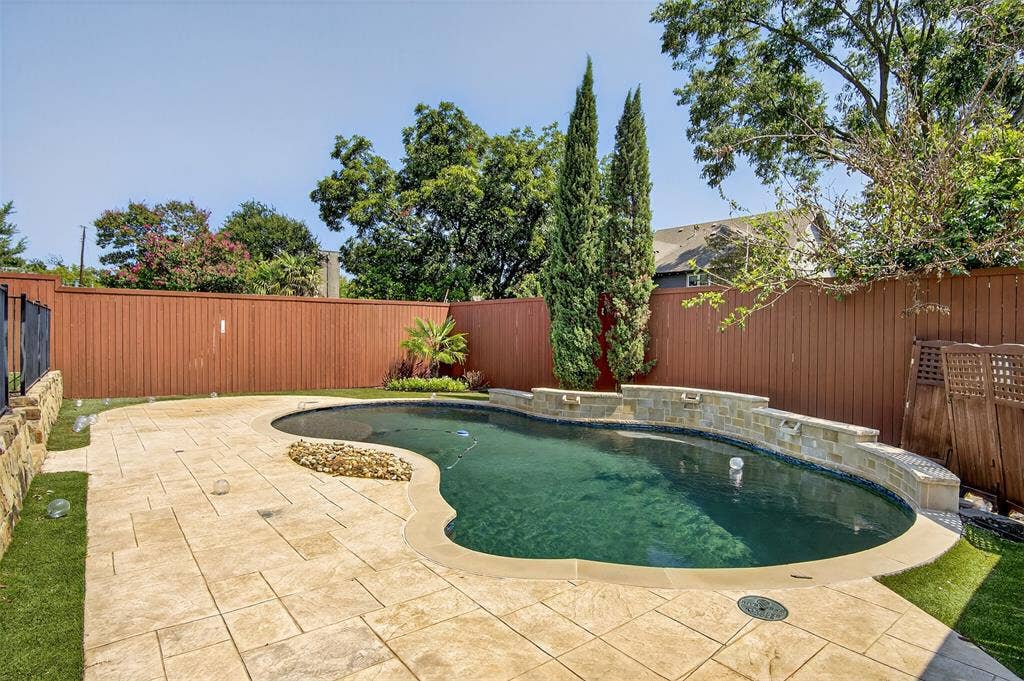 5328 Manett Street, Dallas, TX 75206 Resort-style pool with stone water features, expansive paver patio, and low-maintenance artificial turf surrounding