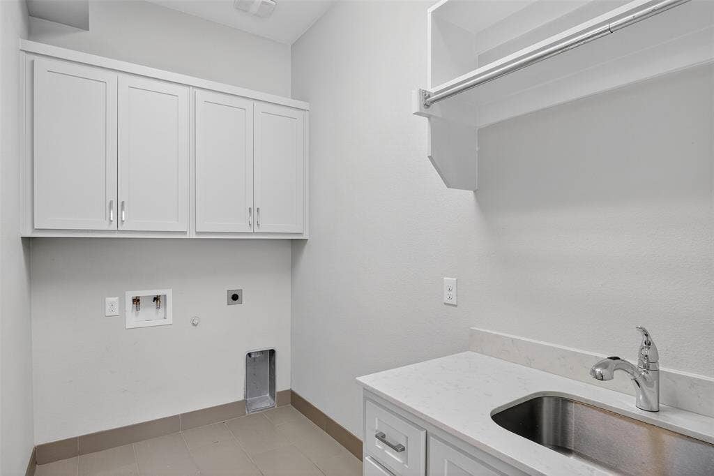 5328 Manett Street, Dallas, TX 75206 White cabinetry, built-in shelving with hanging rod, stainless steel sink, chrome faucet, and light-toned countertops
