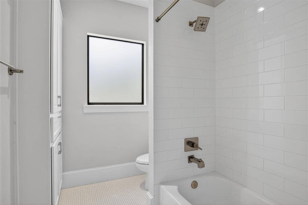 5328 Manett Street, Dallas, TX 75206 Bathtub with subway tile surround, brushed nickel fixtures, and a rain showerhead