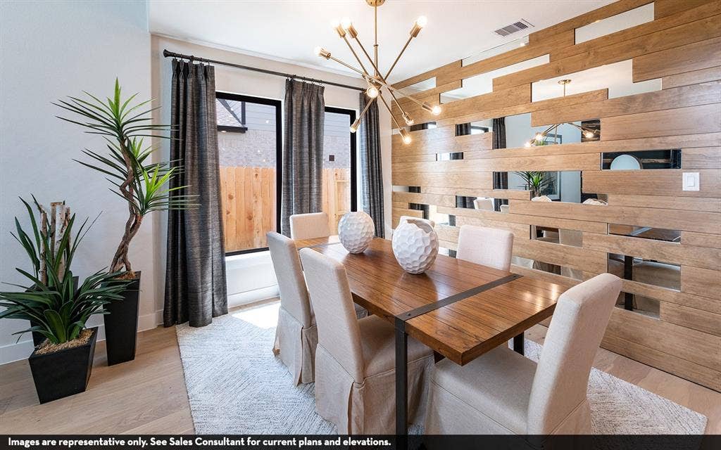 810 Metcalf Drive, Princeton, TX 75071 Wood-finish flooring, accent wall with wood-finish panels and reflective inserts, contemporary chandelier, and large windows with dark drapery