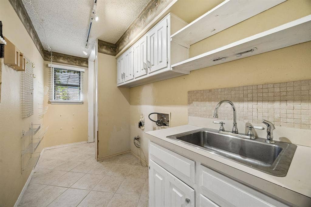 The laundry room features lots of storage and a sink.
