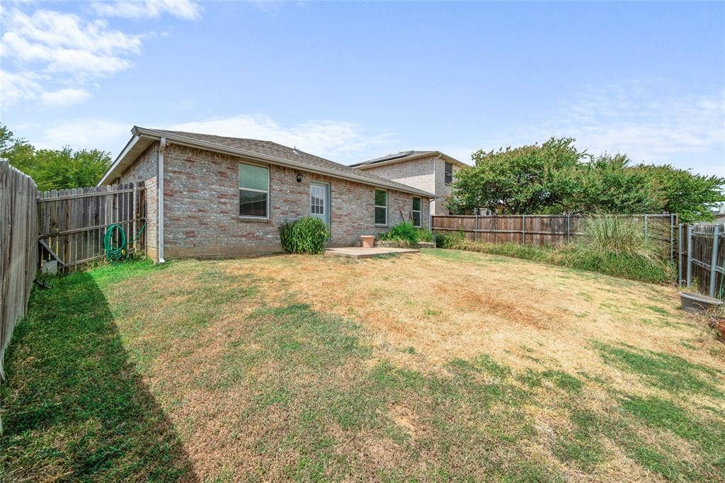 8421 Cotton Valley Lane, Arlington, TX 76002 Brick exterior with a gabled roof and a wooden privacy fence