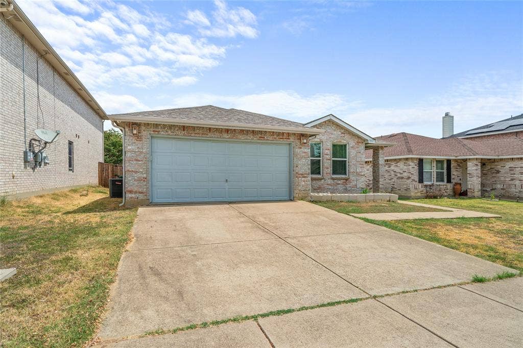 8421 Cotton Valley Lane, Arlington, TX 76002 Full brick exterior, attached garage, concrete driveway, and established landscaping