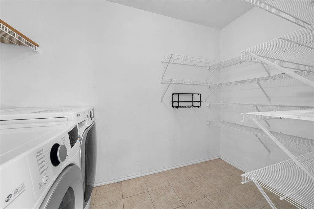 8421 Cotton Valley Lane, Arlington, TX 76002 Dedicated laundry room featuring front-load washer and dryer, tile flooring, wire shelving for ample storage, and a window for natural light