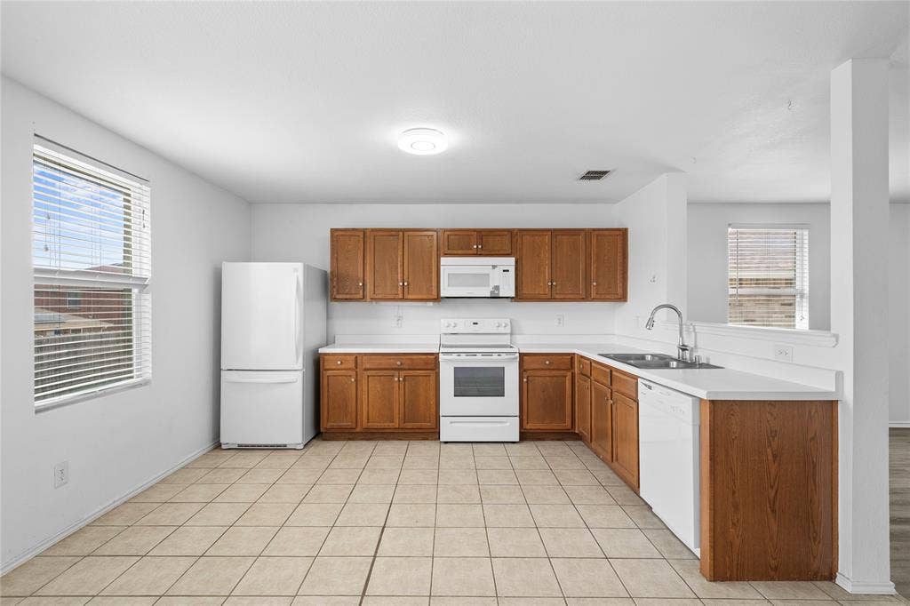 8421 Cotton Valley Lane, Arlington, TX 76002 Kitchen featuring tiled flooring, wood cabinetry, white countertops, and white appliances