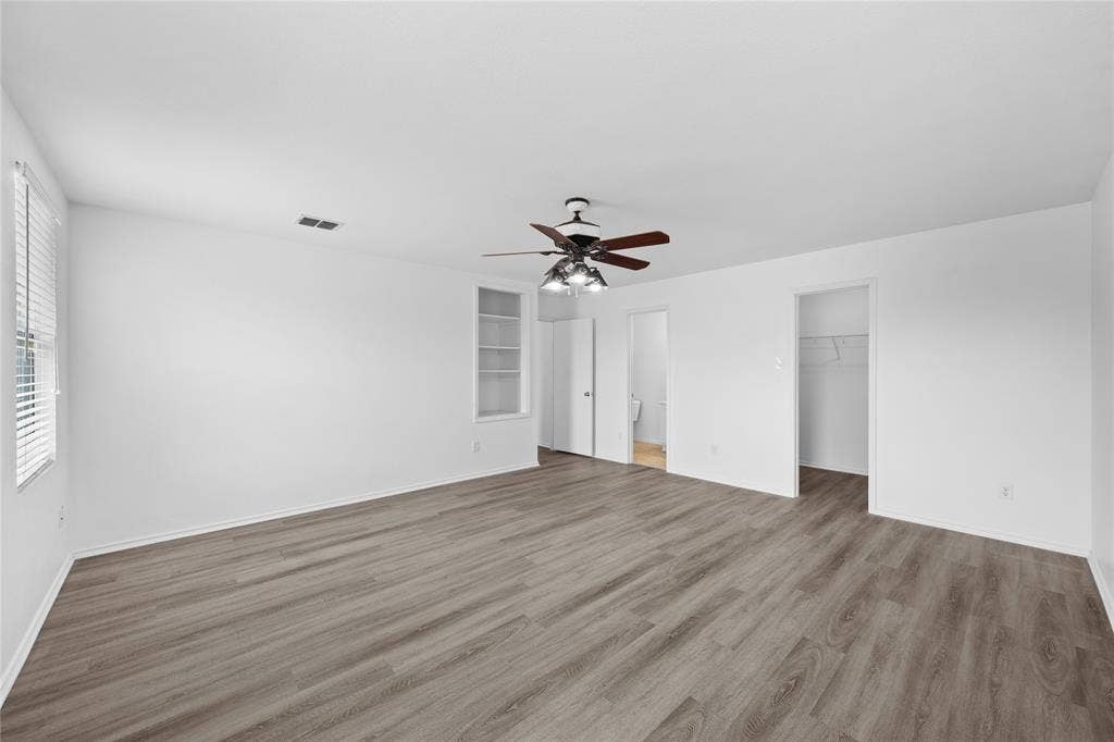 8421 Cotton Valley Lane, Arlington, TX 76002 Spacious room featuring wood-finish flooring, a ceiling fan, and built-in shelving