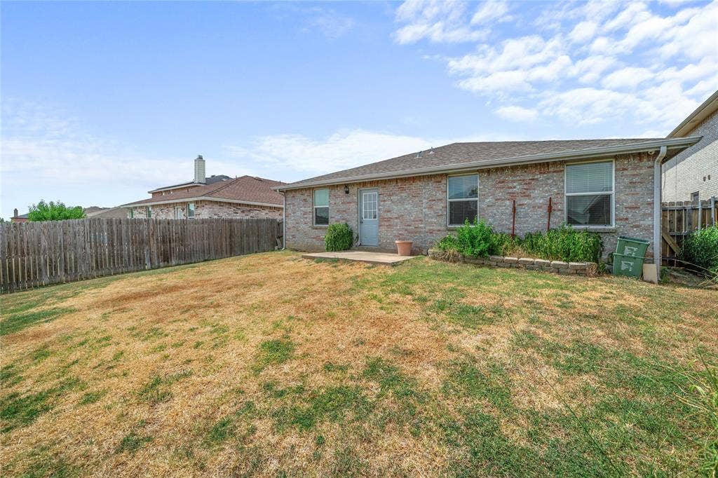 8421 Cotton Valley Lane, Arlington, TX 76002 Brick exterior featuring two windows, a service door, and an exterior patio