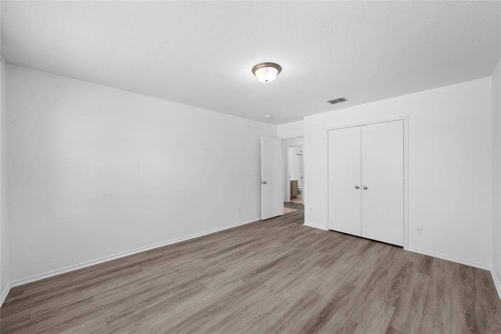 8421 Cotton Valley Lane, Arlington, TX 76002 Wood-finish flooring, flush mount ceiling light, white bi-fold closet doors, white interior door