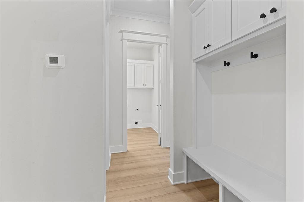 13914 Cedar Hill Lane, Tyler, TX 75704 Built-in storage bench with overhead cabinetry and matte black hardware, wood-finish flooring, and crown molding