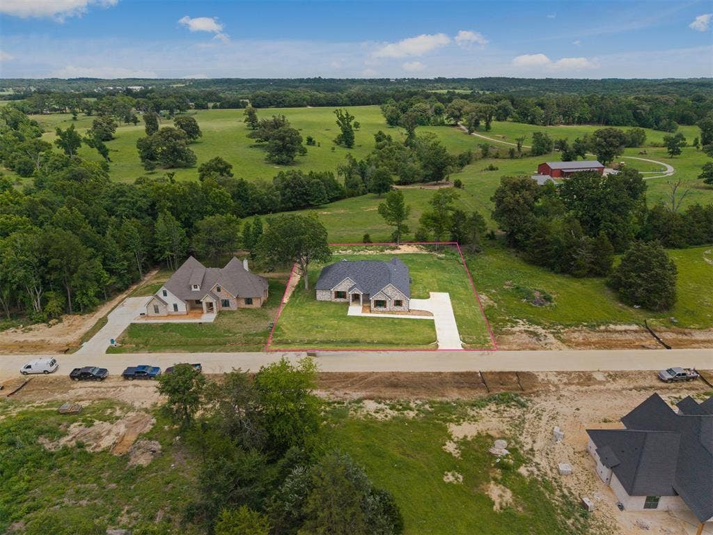 13914 Cedar Hill Lane, Tyler, TX 75704 New construction residence featuring a light-toned brick exterior, a dark-toned roof, and a concrete driveway