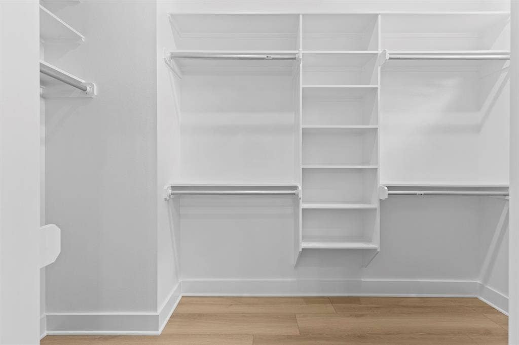 13914 Cedar Hill Lane, Tyler, TX 75704 Built-in closet shelving with multiple hanging rods and wood-finish flooring