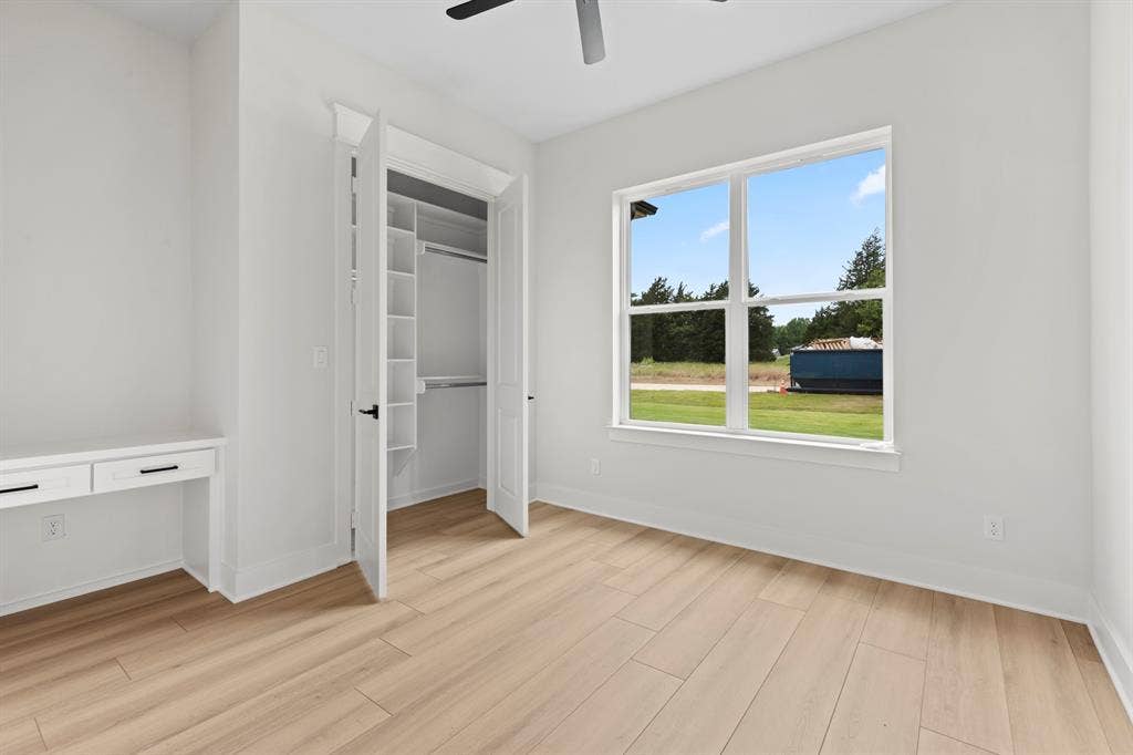 13914 Cedar Hill Lane, Tyler, TX 75704 Wood-finish flooring, built-in desk with drawers, built-in closet shelving, ceiling fan, and large window