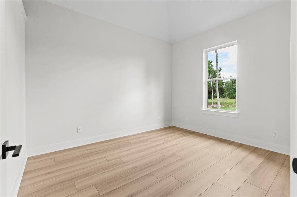 13914 Cedar Hill Lane, Tyler, TX 75704 Neutral white walls, wood-finish flooring, and a single window with white trim