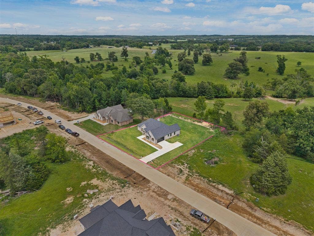 13914 Cedar Hill Lane, Tyler, TX 75704 New construction residence featuring a dark gray roof, light-colored exterior, and an expansive green lawn
