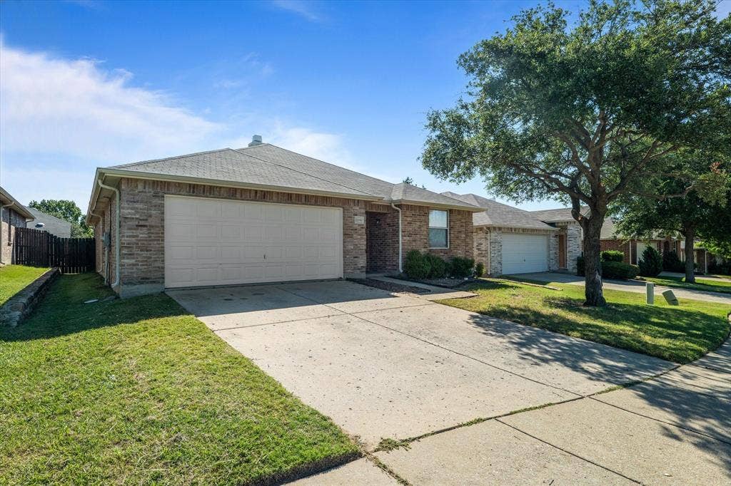 12856 Gillon Drive, Frisco, TX 75035 Single story home with an attached garage, concrete driveway, a shingled roof, and brick siding