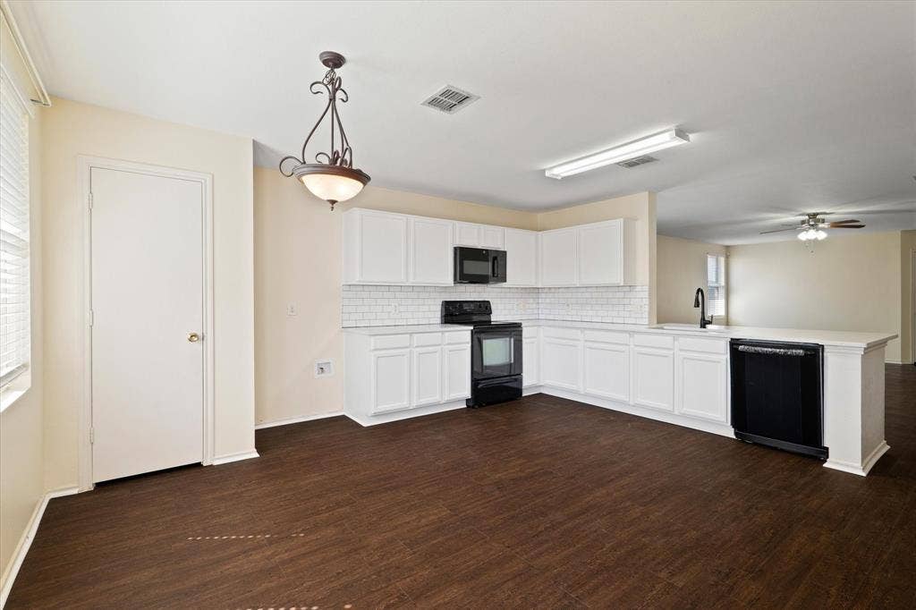 12856 Gillon Drive, Frisco, TX 75035 Kitchen with backsplash, a peninsula, black appliances, light countertops, and dark wood-type flooring