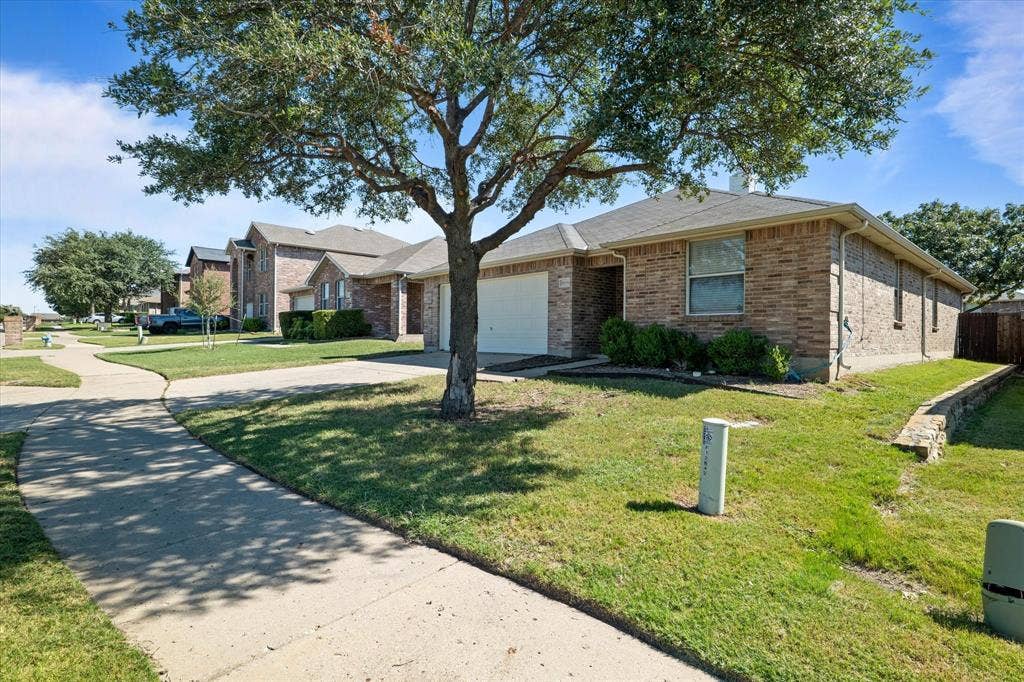12856 Gillon Drive, Frisco, TX 75035 Single story home featuring driveway, an attached garage, brick siding, and a residential view