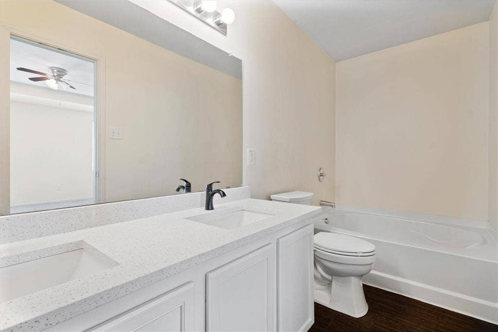 12856 Gillon Drive, Frisco, TX 75035 Full bath with wood finished floors, double vanity, a tub to relax in, and a ceiling fan