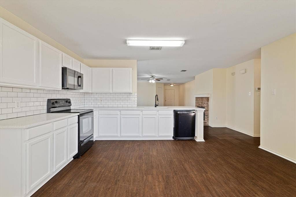 12856 Gillon Drive, Frisco, TX 75035 Kitchen with black appliances, backsplash, a peninsula, white cabinets, and dark wood-type flooring