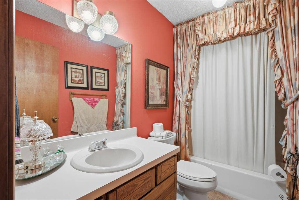 6146 County Road 334, Tyler, TX 75708 Integrated vanity with a single basin sink, wood-finish cabinetry, and a full-width mirror