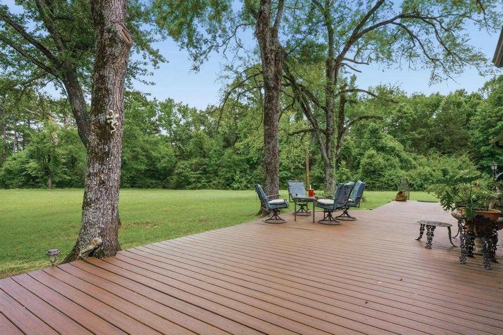 6146 County Road 334, Tyler, TX 75708 Expansive wood-finish deck with a spacious lawn and mature trees