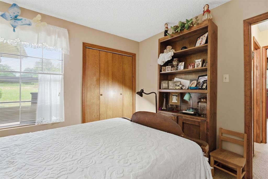 6146 County Road 334, Tyler, TX 75708 Double-pane window with blinds, wood-finish closet doors, and a built-in wood-finish bookcase
