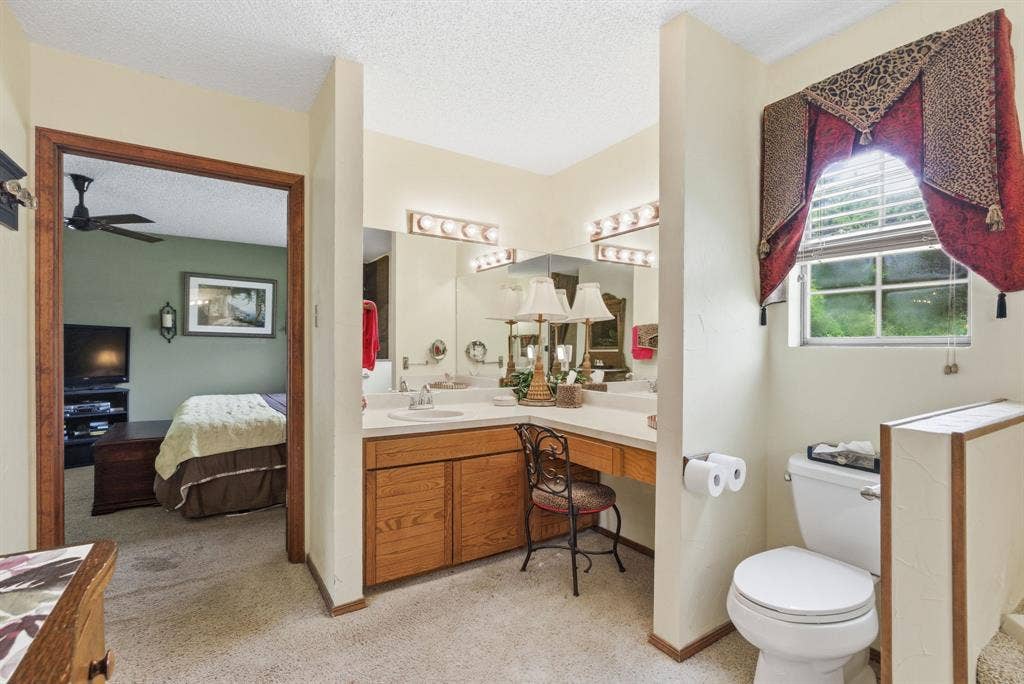 6146 County Road 334, Tyler, TX 75708 Dual vanity with integrated sinks, wood-finish cabinetry, and overhead lighting