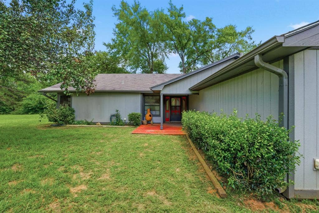 6146 County Road 334, Tyler, TX 75708 Exterior featuring a light-colored siding, a dark roof, and a covered entry with a red-toned porch