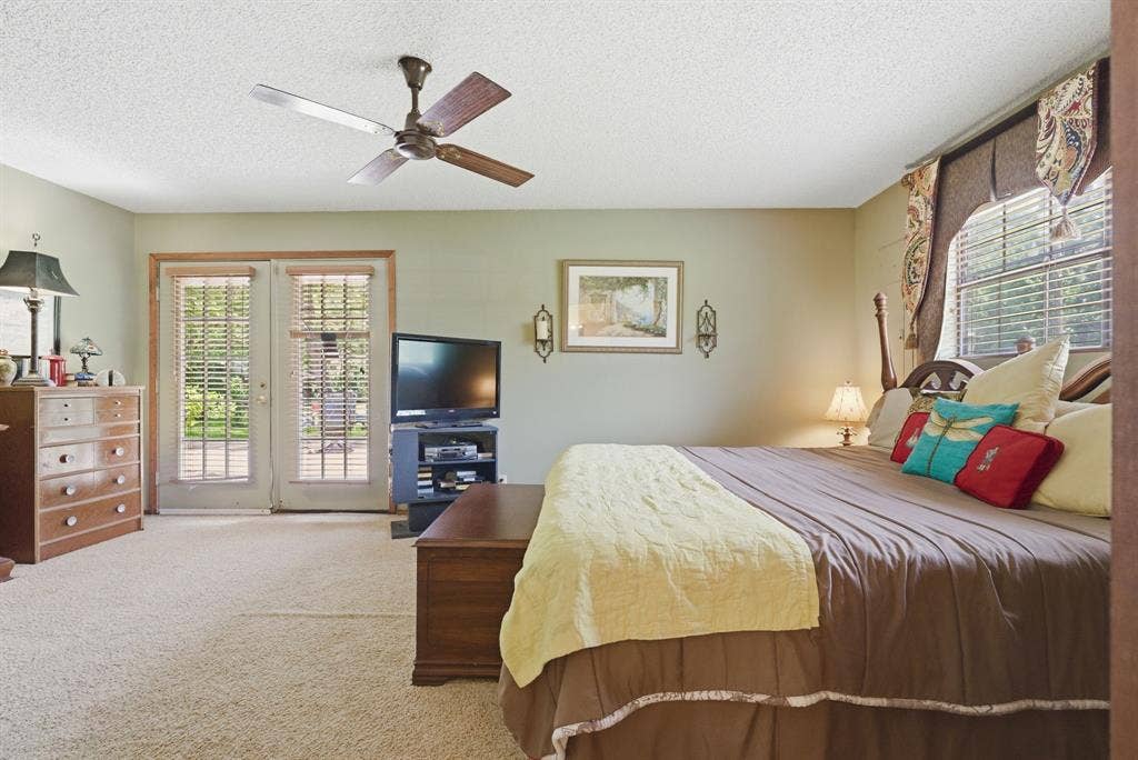 6146 County Road 334, Tyler, TX 75708 Ceiling fan, wall-to-wall carpeting, double French doors, large window with blinds, and neutral wall paint