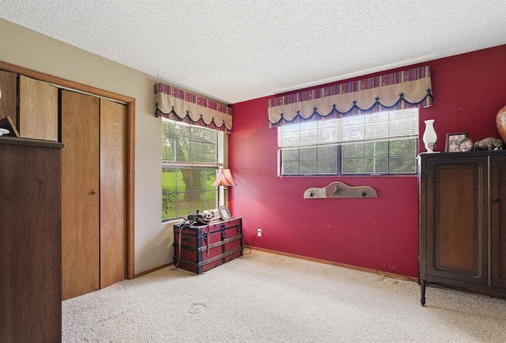 6146 County Road 334, Tyler, TX 75708 Light-colored carpeting, two windows with blinds, and wood-finish bi-fold closet doors
